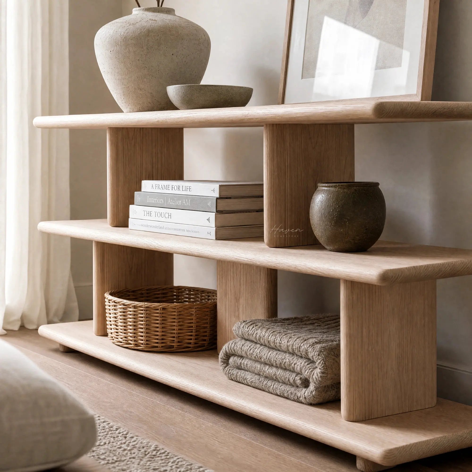 Norr Shelves in natural oak with a layered open design, displaying books, ceramics and decorative bowls.