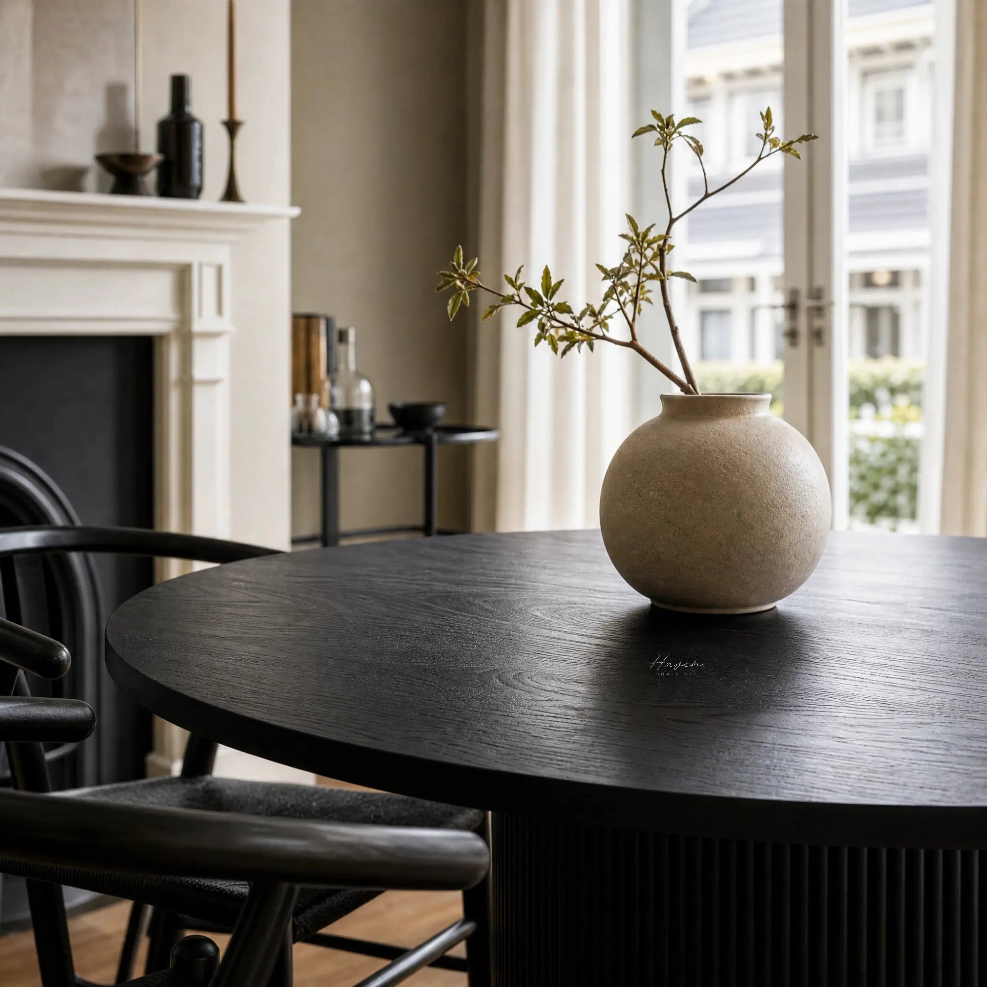 Sora Dining Table in Black with a round top and fluted pedestal base, fir wood and timber veneer.
