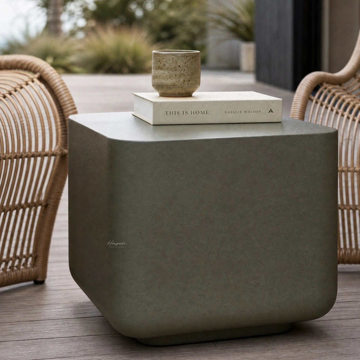 Vista Bowie Square Side Table in pinhole textured GRC with a stone finish on an outdoor patio, ceramic cup on a book