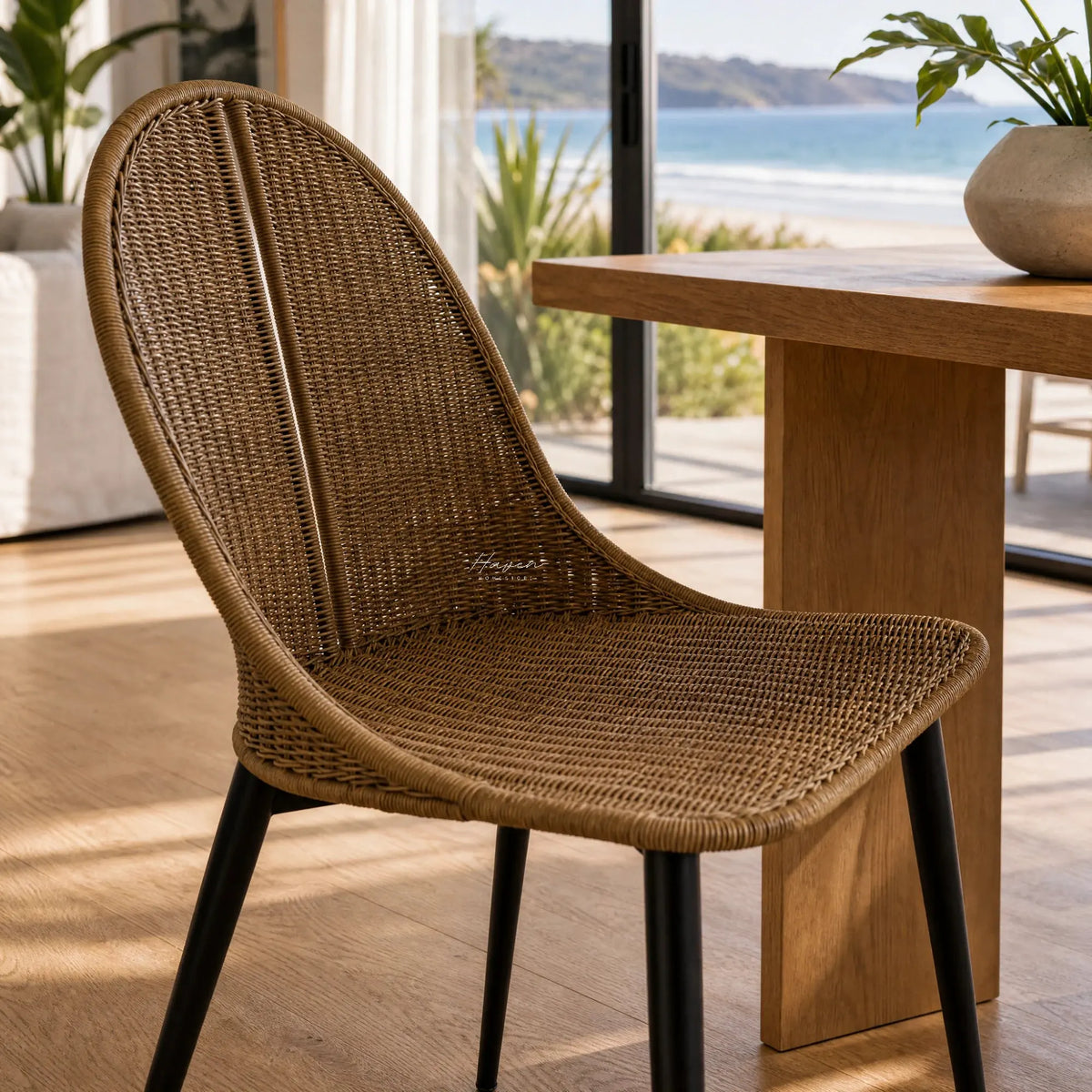 Celeste Dining Chair: woven rattan back and seat with sleek black legs, coastal style