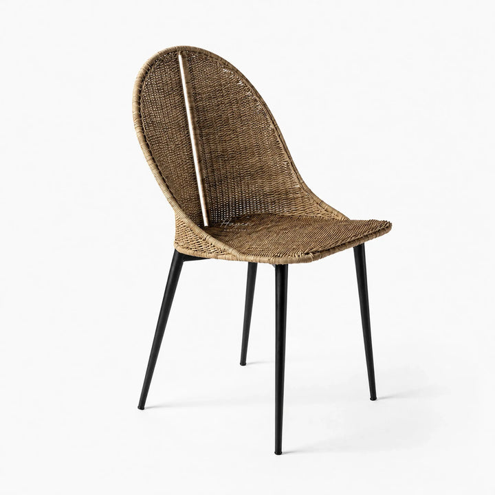 Celeste Dining Chair with natural woven rattan and curved silhouette on black metal legs.