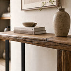 Timberline Reclaimed Console with knotty pine top and steel base, styled with a vase and stacked books.