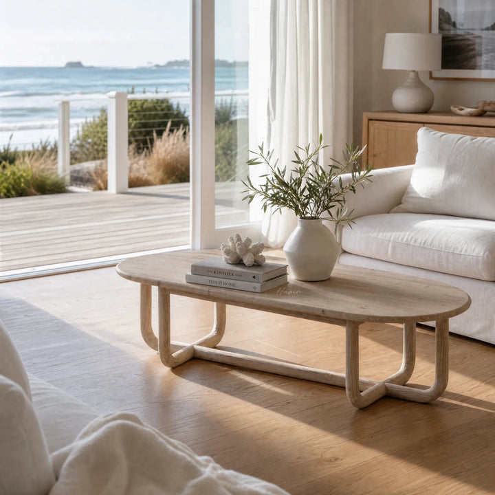 Jones Coffee Table in a light chalk-washed finish with curved silhouette, recycled pine, shown in coastal living room.