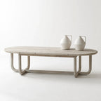 Jones Coffee Table in light chalk-washed wood with curved silhouette, shown with three white ceramic vases.