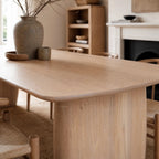 Alva Dining Table in solid ash with milkwash finish, paired with a ceramic vase and bowls in a Nordic dining room.