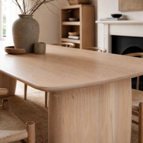 Alva Dining Table in solid ash with milkwash finish, paired with a ceramic vase and bowls in a Nordic dining room.