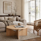 Kristina Dam Simple Table, FSC-certified oak round coffee table with sculptural silhouette in a serene living room.