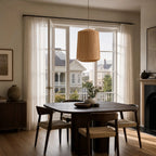Ren Lampshade - Natural, woven jute pendant over a round wooden dining table in a sunlit dining room.