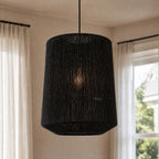 Ren Lampshade - Black woven shade hanging with warm, diffused light.