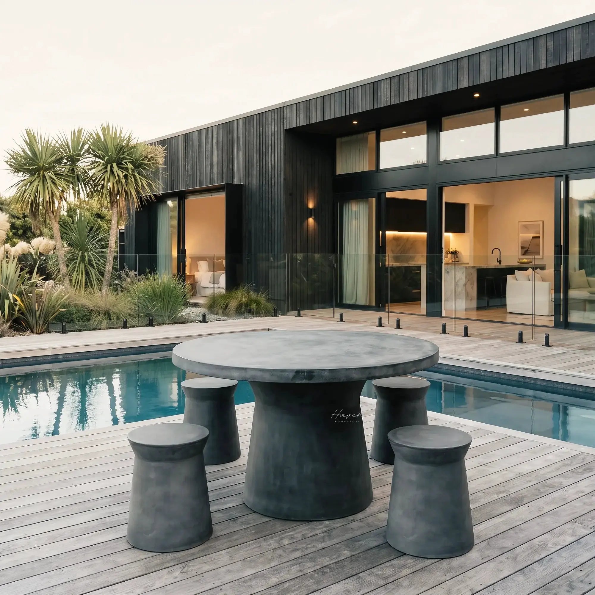 Broste Outdoor Dining Table on a modern deck with sculptural fiberclay pedestal bases, concrete-like finish.