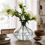 Ingrid Glass Vase in smoky glass with suspended bubbles and a petal-shaped rim, shown with simple stems.