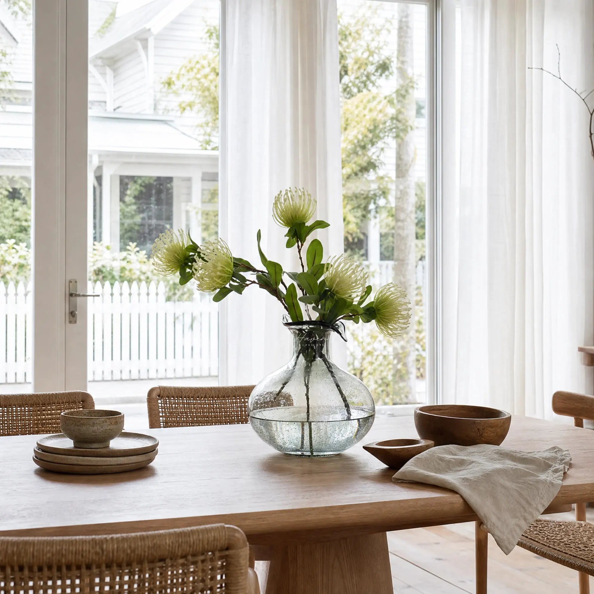 Ingrid Glass Vase with smoky hue, suspended bubbles and petal-shaped rim, displayed with stems on a dining table.