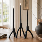 Two black cast-iron candleholders with tree-branch silhouettes, MUUBS Aion Set/2.