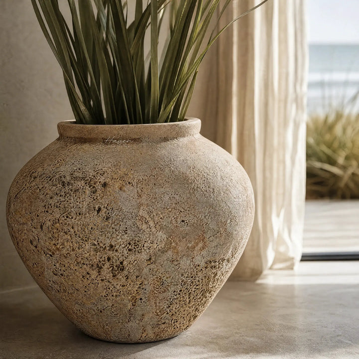 MUUBS Pot Trace 30 Coral/Sand terracotta planter with tall green leaves indoors.