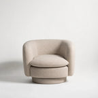 Monika Swivel Chair - Latte: soft beige fabric, curved back, and swivel base.