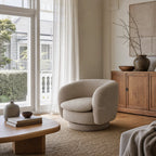 Monika Swivel Chair - Latte with a soft sculptural silhouette, curved back, and swivel base in a cozy living room.