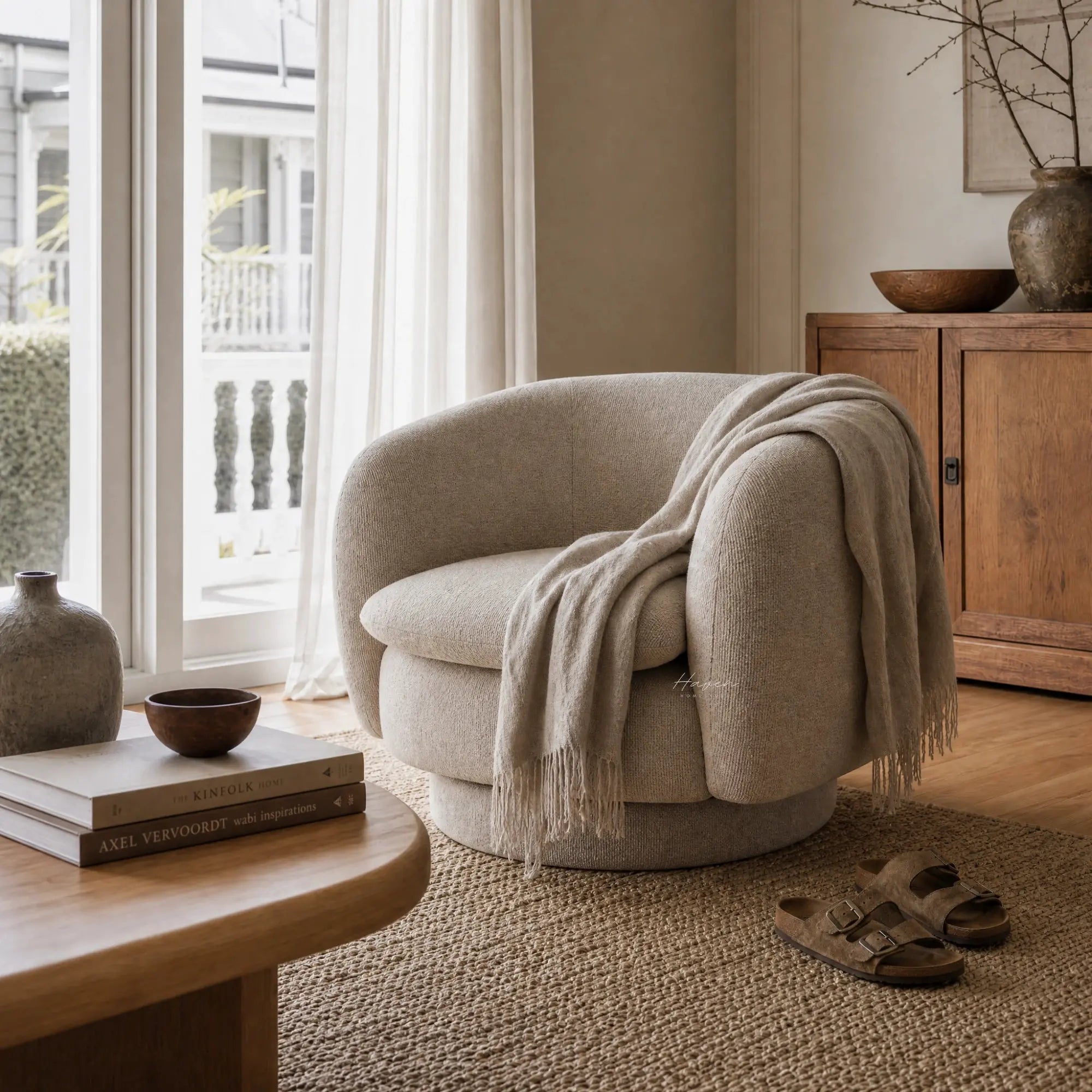 Monika Swivel Chair - Latte with soft curved back and cozy throw in a sunlit living room.