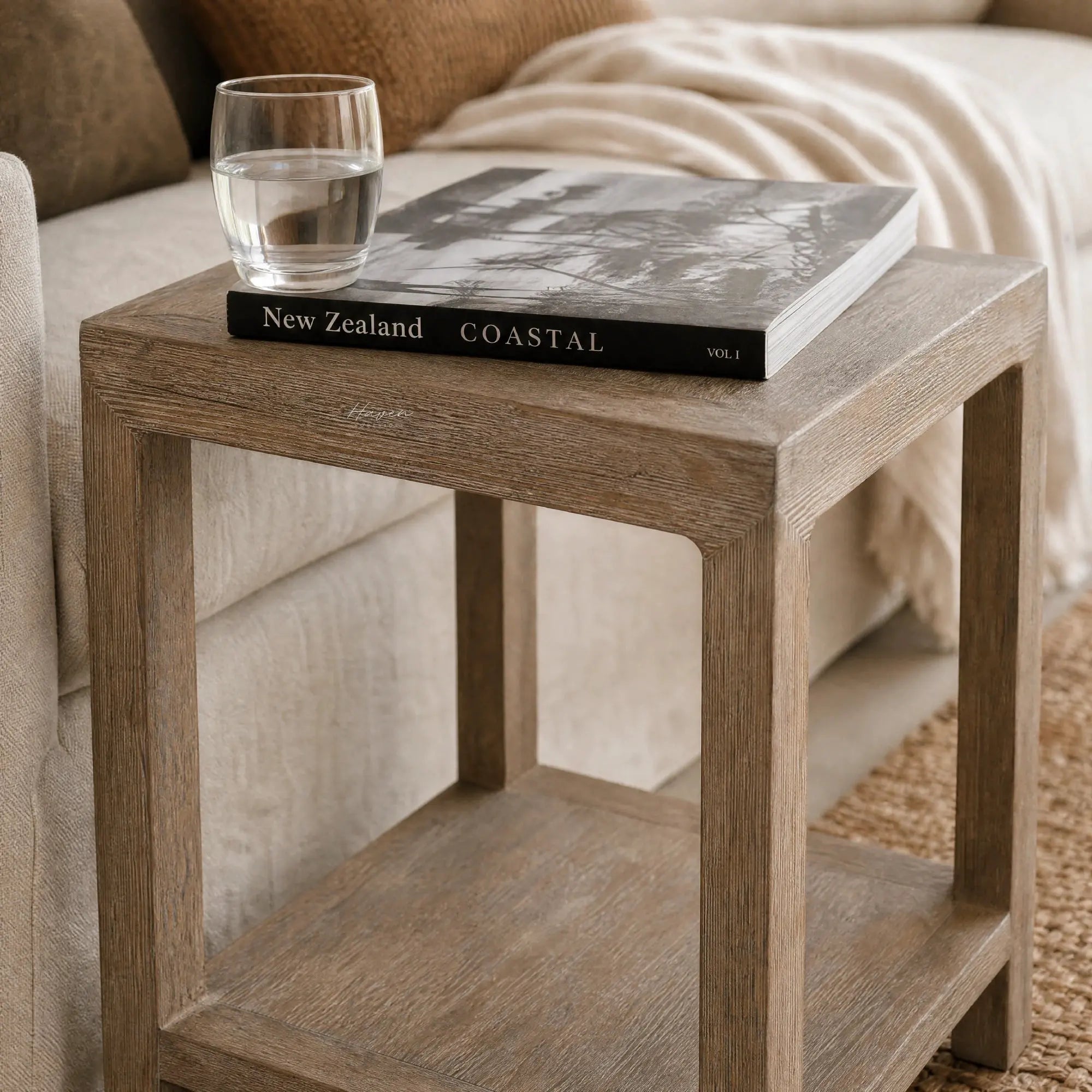 Driftwood Side Table in weathered pine with coastal warmth; glass of water atop a coastal book.