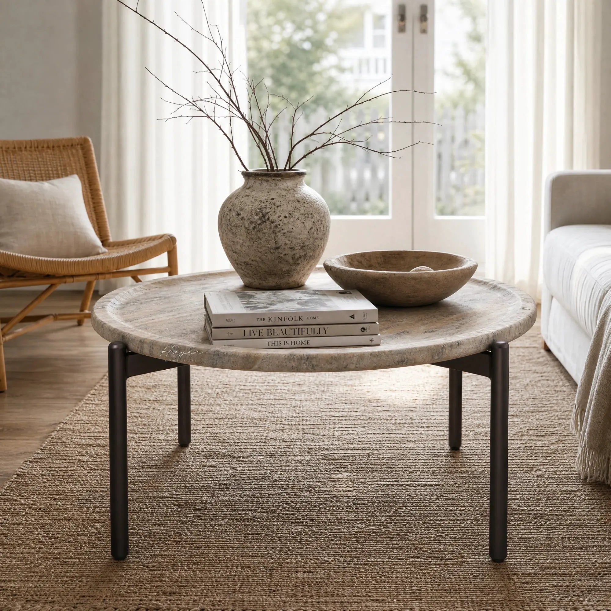 Sigrid Coffee Table with a round dark travertine-like GRC top and chocolate-brown metal legs in a sunlit living room