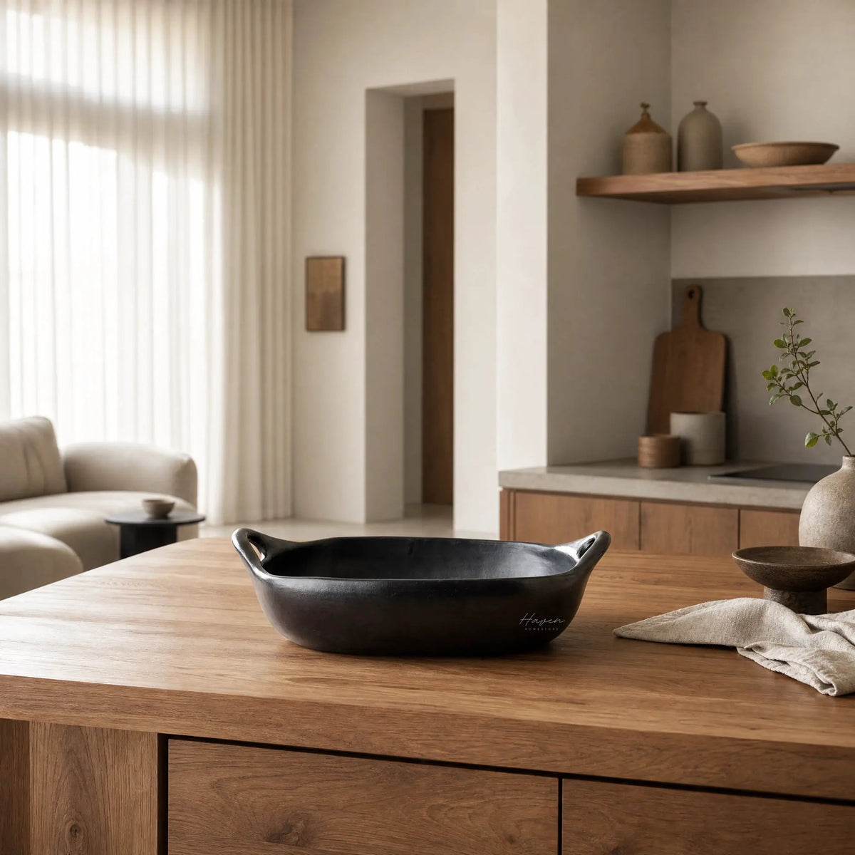 La Chamba Baking Dish on a wooden kitchen island, showcasing dark clay and artisanal craftsmanship.