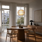 Kura Pendant Light with bamboo open-weave shade, softly diffused glow over round wooden dining table.