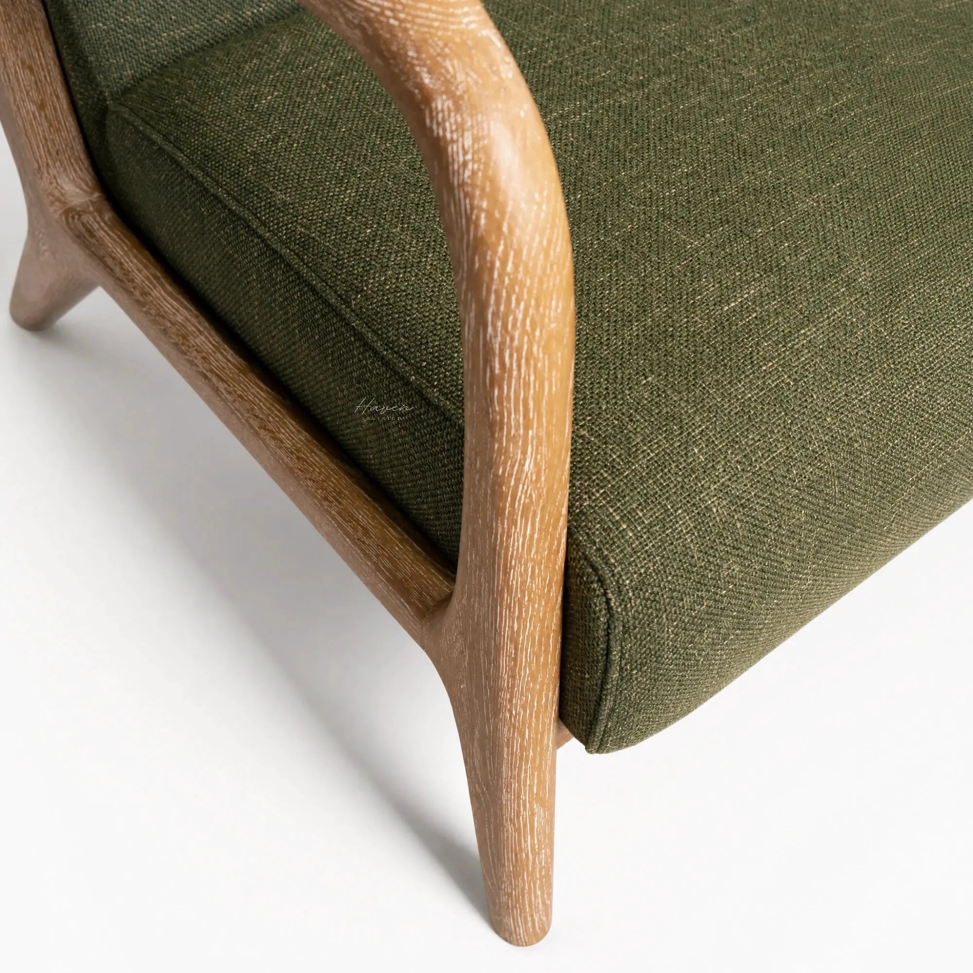Tairua Lounge Chair in Seagrass with limewashed oak frame and textured green upholstery.