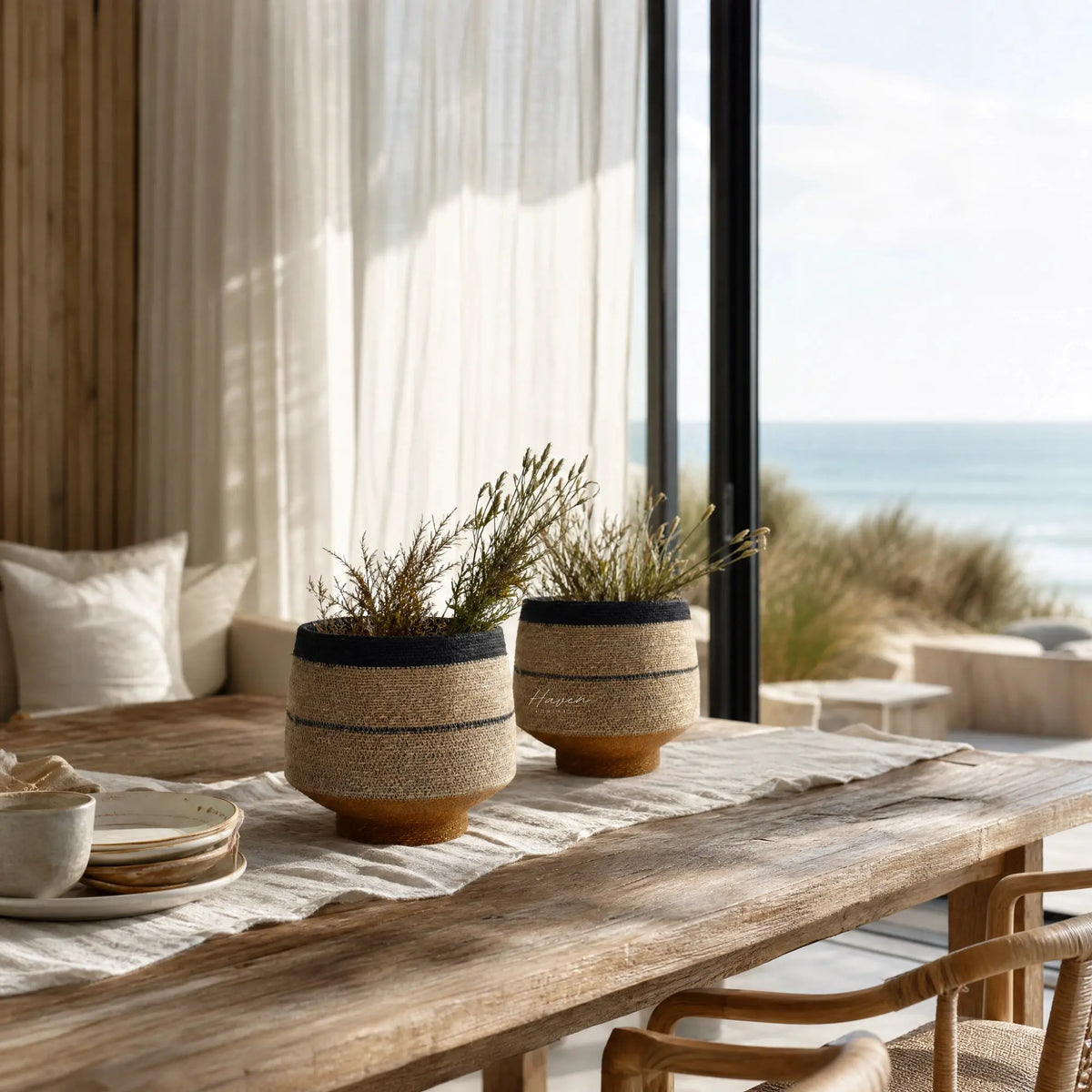 Pari Basket Set/2: handwoven seagrass baskets with denim blue stripe and mustard base on a rustic wooden table.