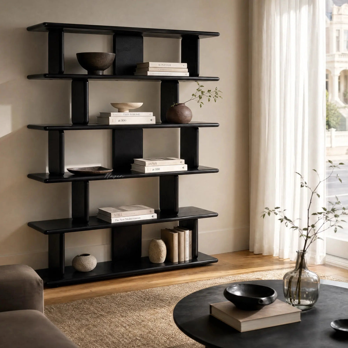 Jansen Shelving Unit - Black on a living room wall, displaying books and ceramics.