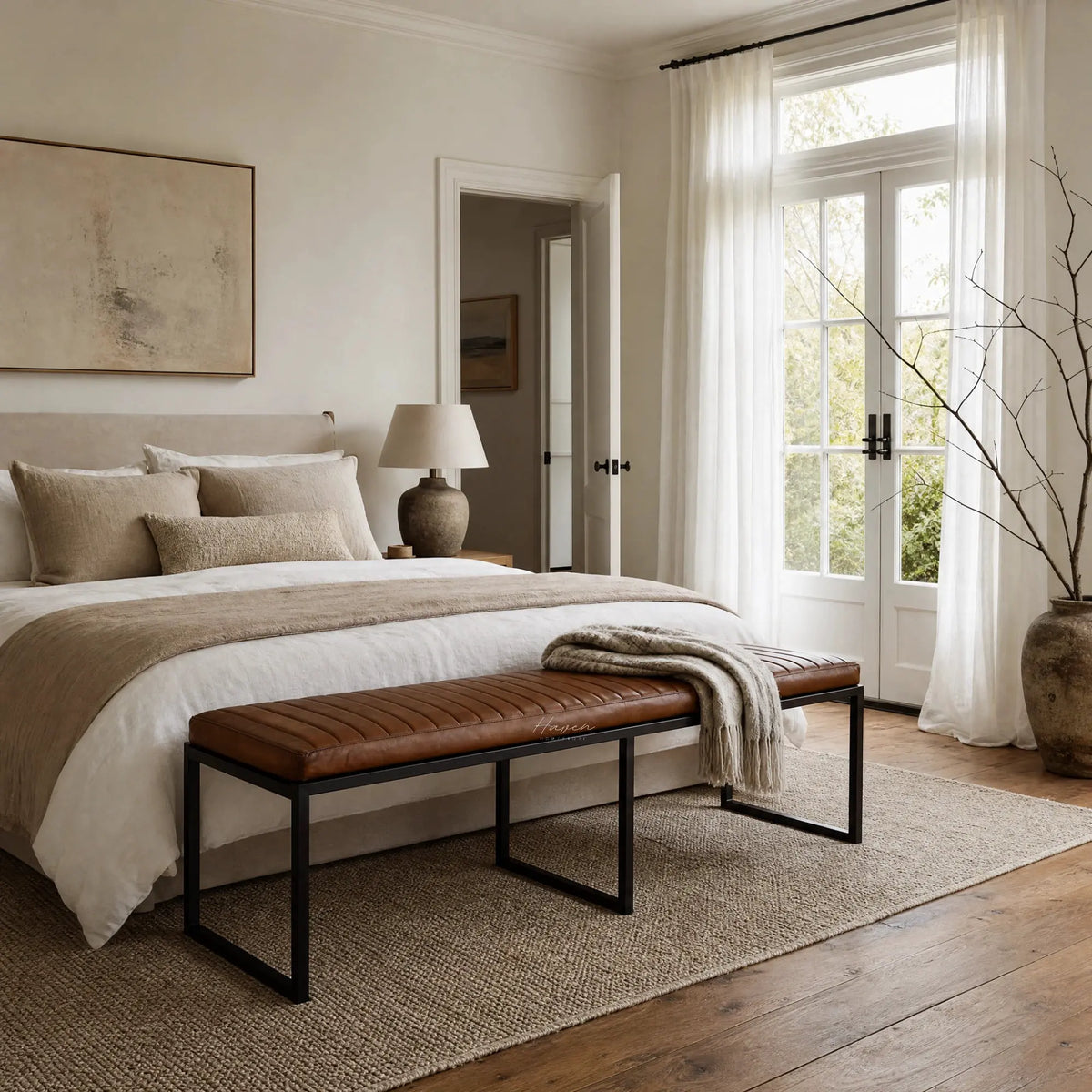 Two Pure® Sabina benches with buffalo leather upholstery and matte black frames at the foot of the bed.