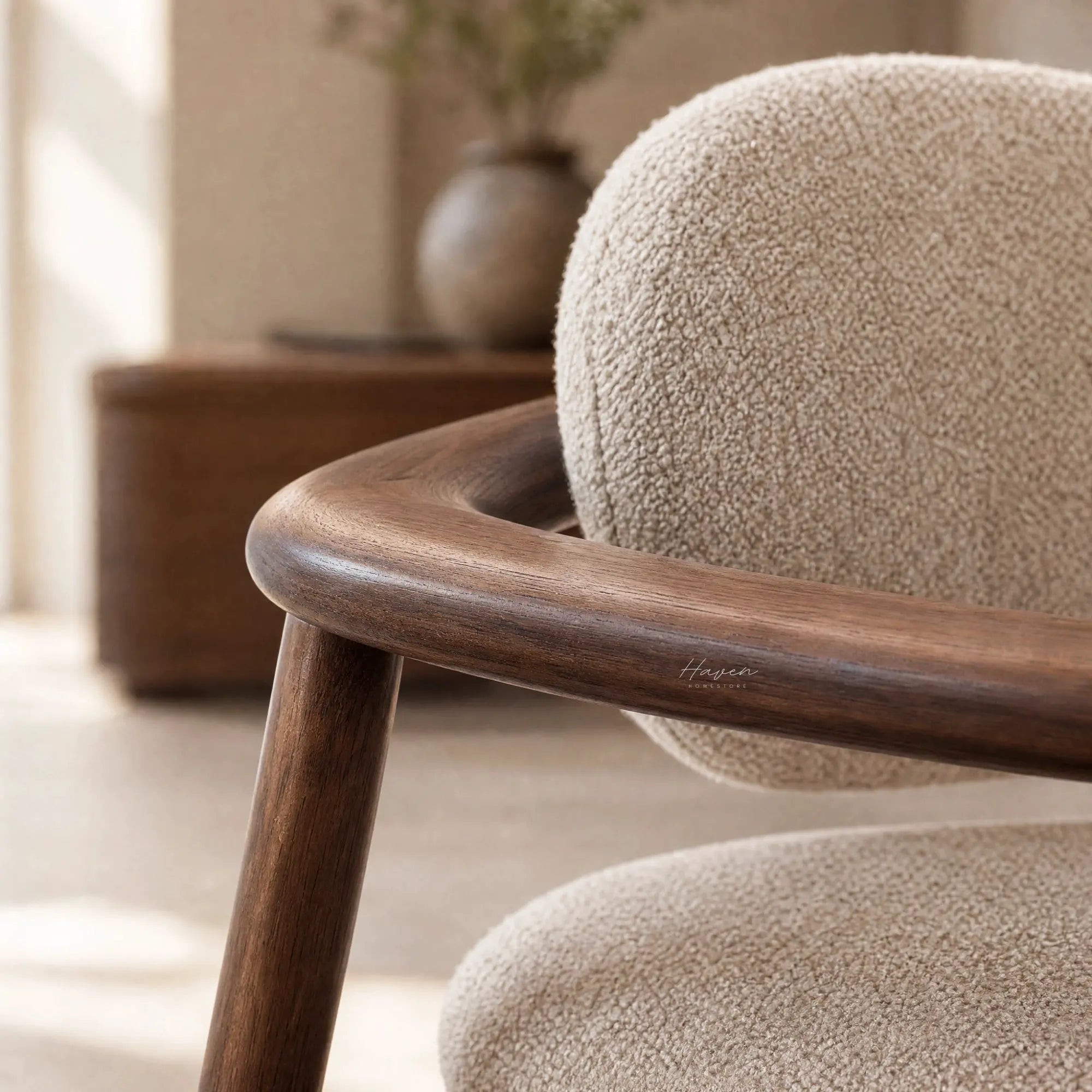 Aster Dining Chair with a solid ash frame, curved arm, and beige boucle upholstered seat in Japandi style.