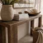 Estuary Console in solid reclaimed elm with rich grain and weathered textures, paired with plants and books.