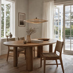 Soren Pendant Light handcrafted from natural bamboo, softly diffusing warm light over a dining table.