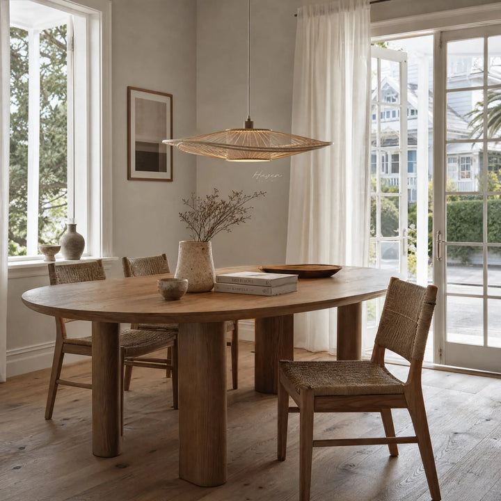 Soren Pendant Light handcrafted from natural bamboo, softly diffusing warm light over a dining table.
