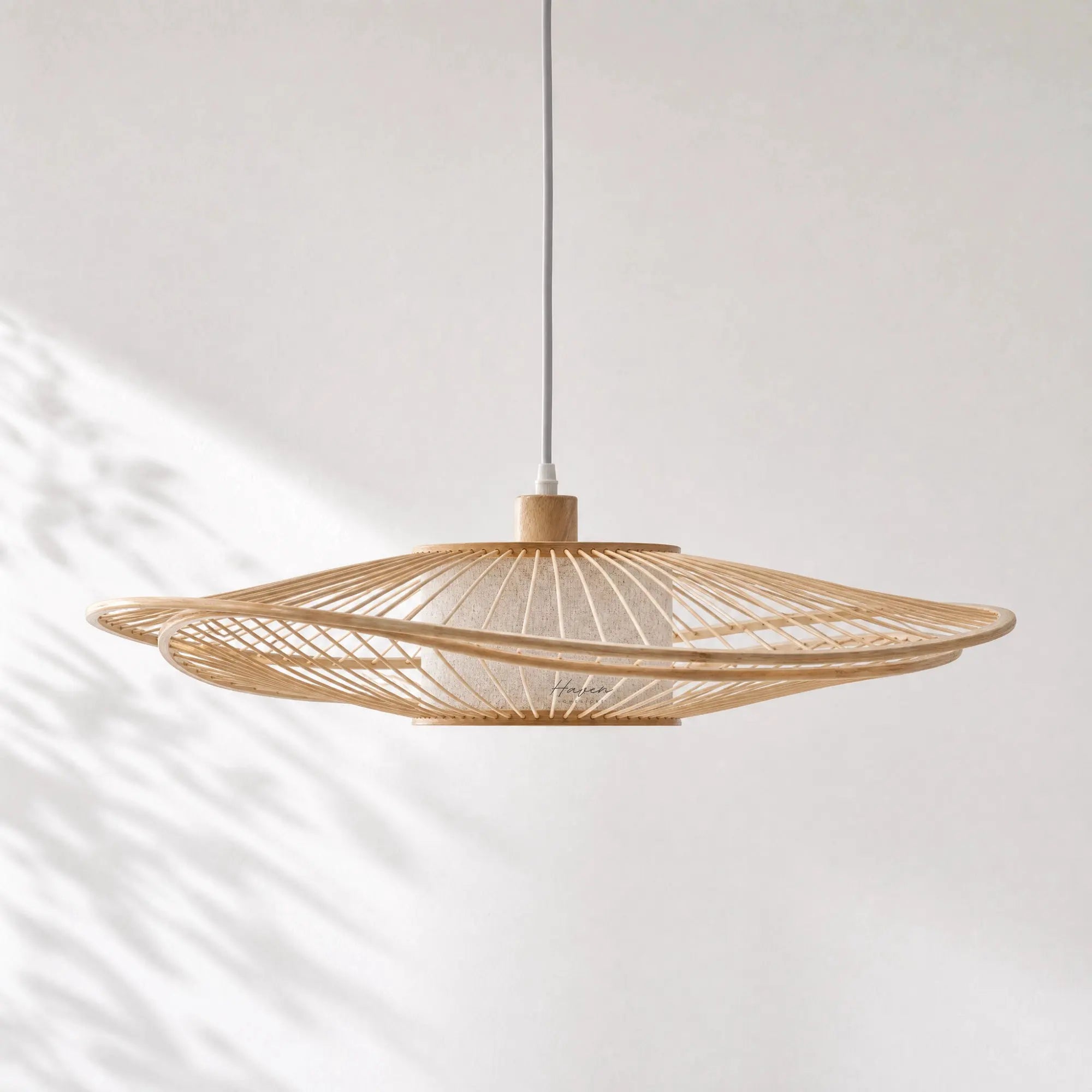 Soren Pendant Light with layered bamboo slat shade, diffusing warm light from a ceiling pendant.