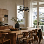 Halo Pendant Light handcrafted from natural bamboo with flowing layered blades, suspended over a wooden dining table.