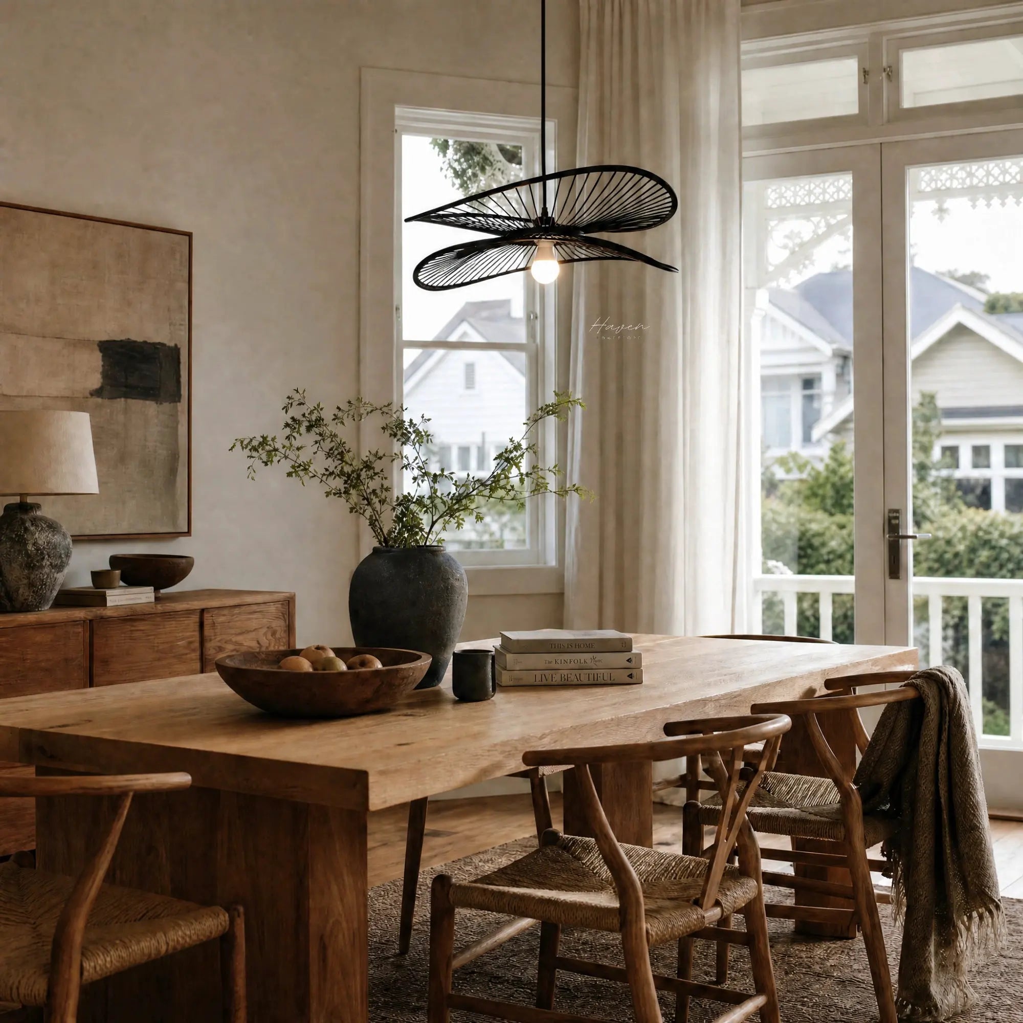 Halo Pendant Light handcrafted from natural bamboo with flowing layered blades, suspended over a wooden dining table.