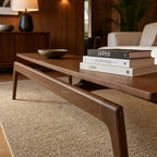 Rowan Coffee Table in American Ash with clean mid-century lines, shown with books and a bowl in a living room.