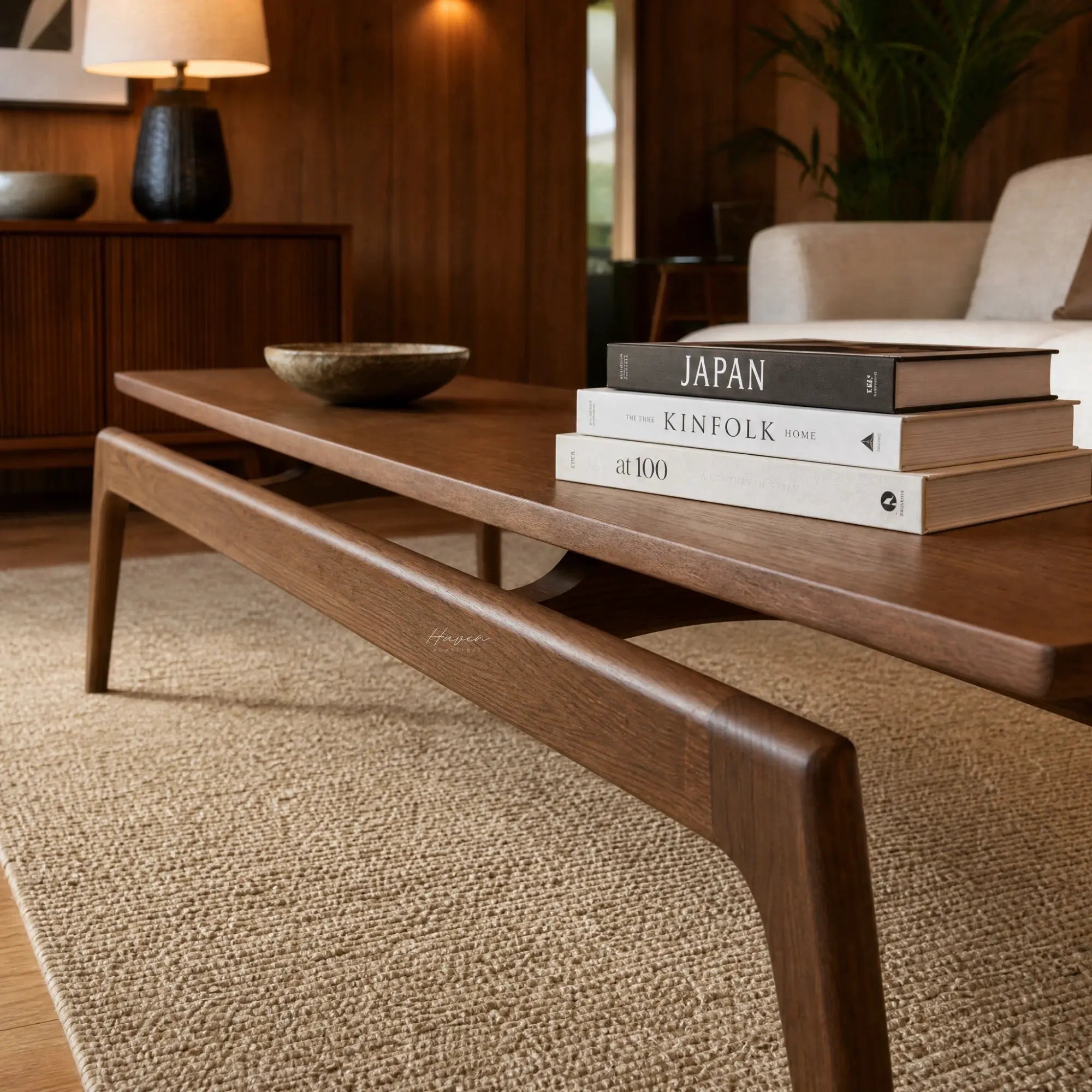 Rowan Coffee Table in American Ash with clean mid-century lines, shown with books and a bowl in a living room.