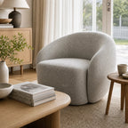 Ingrid Swivel Chair in Mist gray textured fabric with rounded silhouette in a cozy living room.