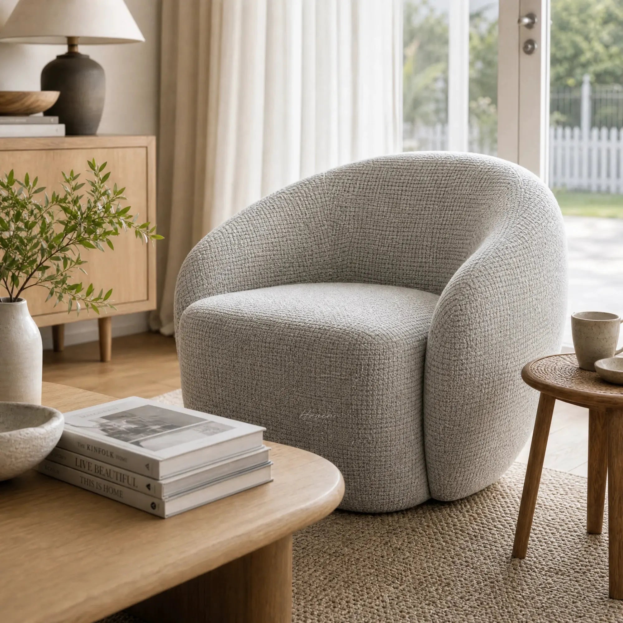 Ingrid Swivel Chair in Mist gray textured fabric with rounded silhouette in a cozy living room.