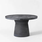 Broste®️ Outdoor Dining Table in fiberclay, round top with sculptural pedestal, concrete-like finish.