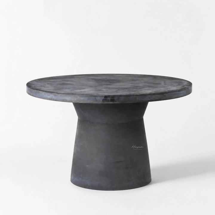 Broste®️ Outdoor Dining Table in fiberclay, round top with sculptural pedestal, concrete-like finish.