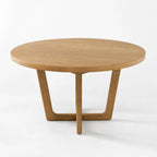 Ashburton Dining Table: round oak top with soft curves and a clean architectural base.