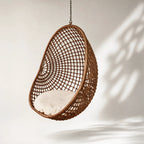 Check Pod Chair hanging wicker pod with lattice weave and beige cushion.