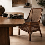 Albany Chair handwoven in natural rattan with a curved silhouette, adding warm texture to a dining space.