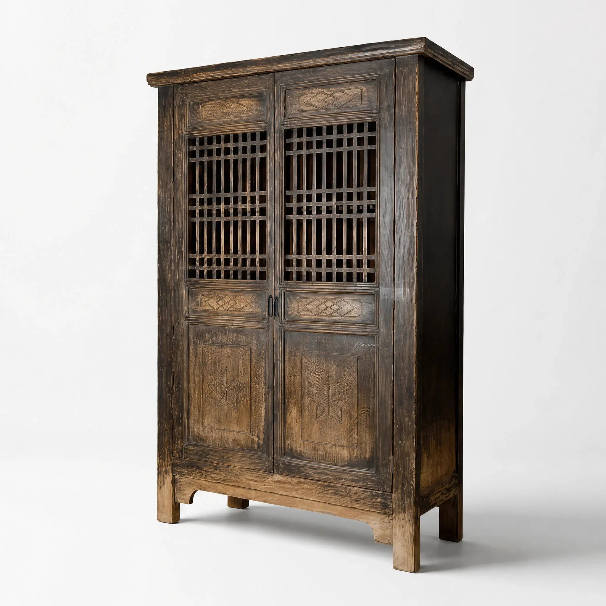 Nomad 2-Door Cabinet in weathered reclaimed pine with carved panels and lattice doors.
