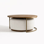 Eleanor Coffee Table + Ottoman: round ashwood top, cushioned gray ottoman, and iron frame.
