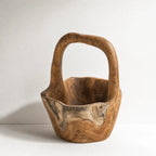 Teak Handle Bowl with a curved handle, rich grain, and sculptural warm texture.