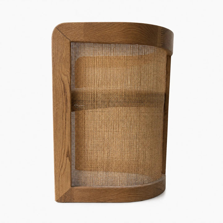 Cove Cane Chair with curved oak frame and woven rattan panels, softly cushioned seat.