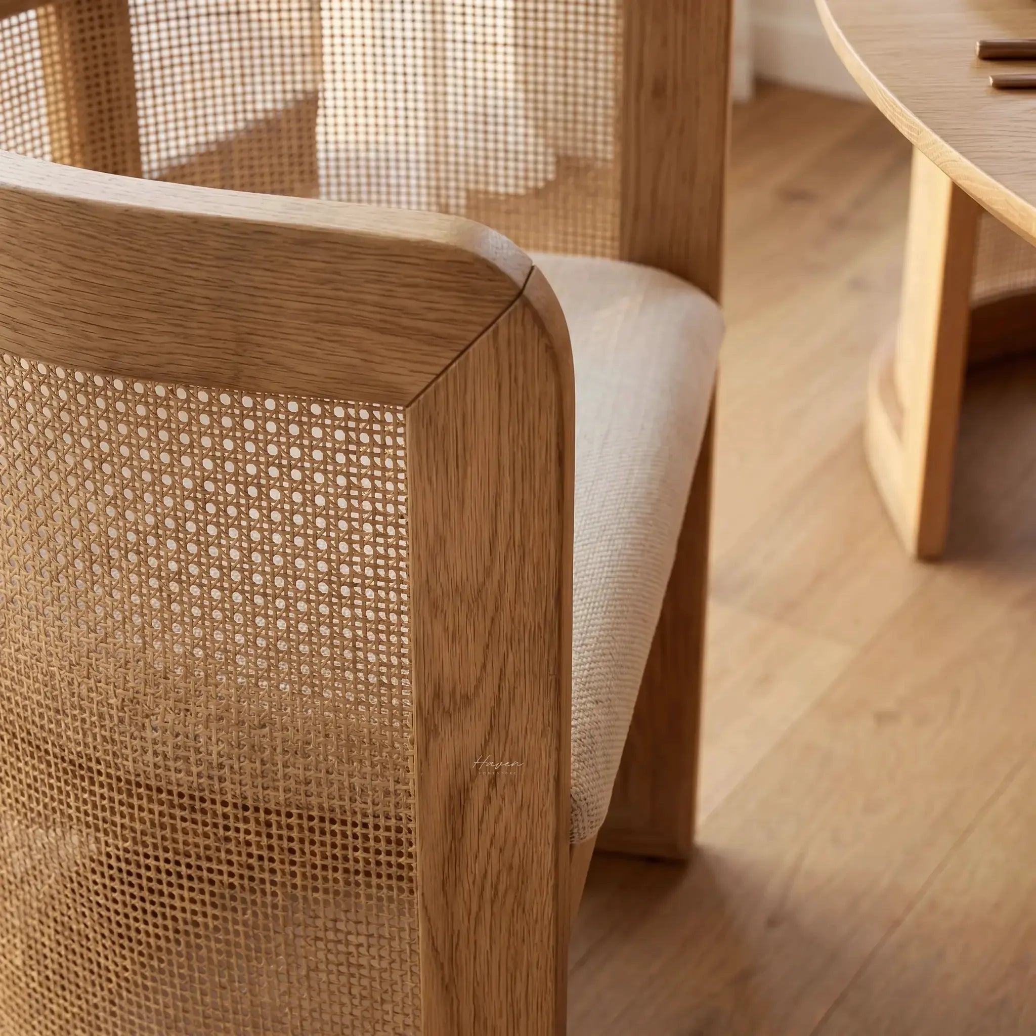 Cove Cane Chair: curved oak frame with woven rattan panels and a softly cushioned seat.